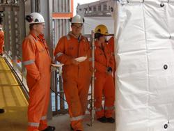 To menn snakker sammen ved en midlertidig oppsatt bu for vaf