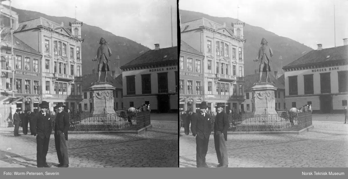 To menn foran Holbergstatuen på Vågallsmenningen i Bergen.