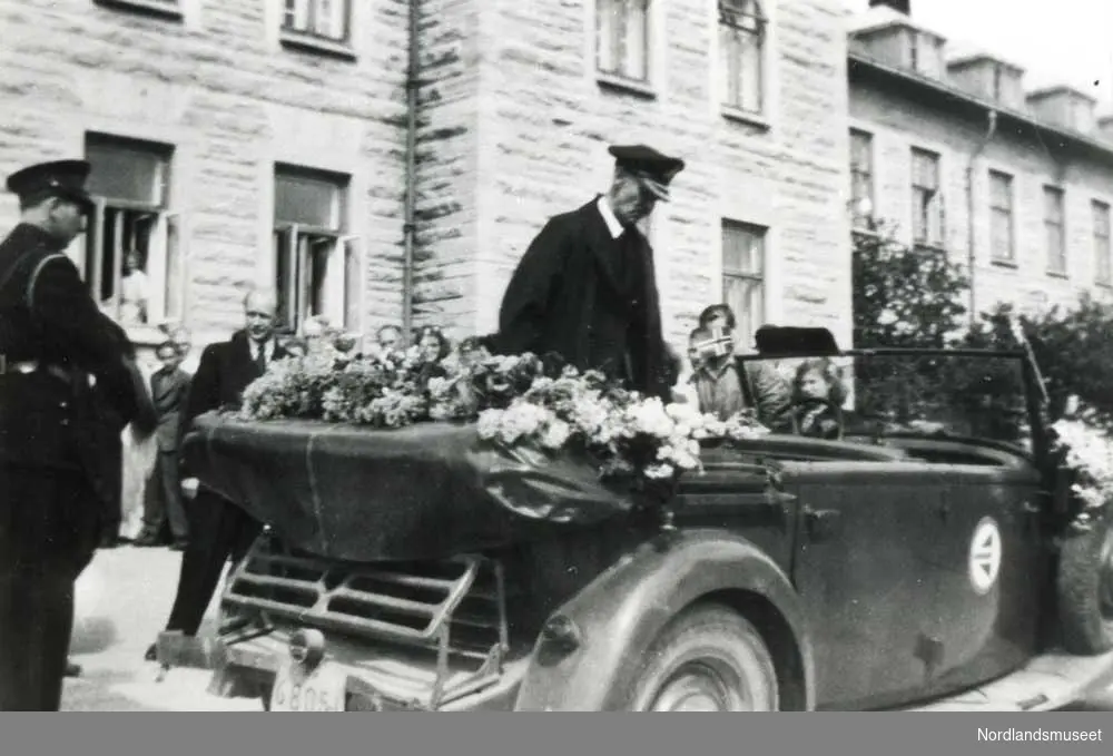 Kong Haakon VII ved sykehuset. Han stiger ombord i en ventende bil.
