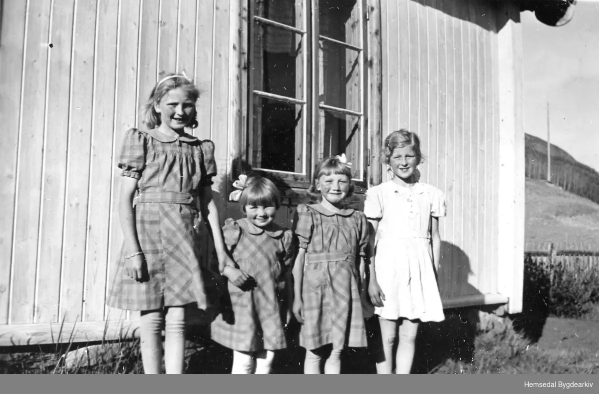 Frå venstre: Margit Wøllo, Solbjørg Wøllo, Gunhild Wøllo, og Barbro Flaten.
Jenten frå Wøllo hadde fått nye kjolar som mor deira både hadde vove stoff til og sydd.
