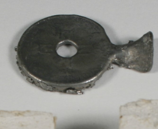 En støpeform (i to deler) og en mynt som ikke er pusset. Formen er til en 1 kronemynt.
