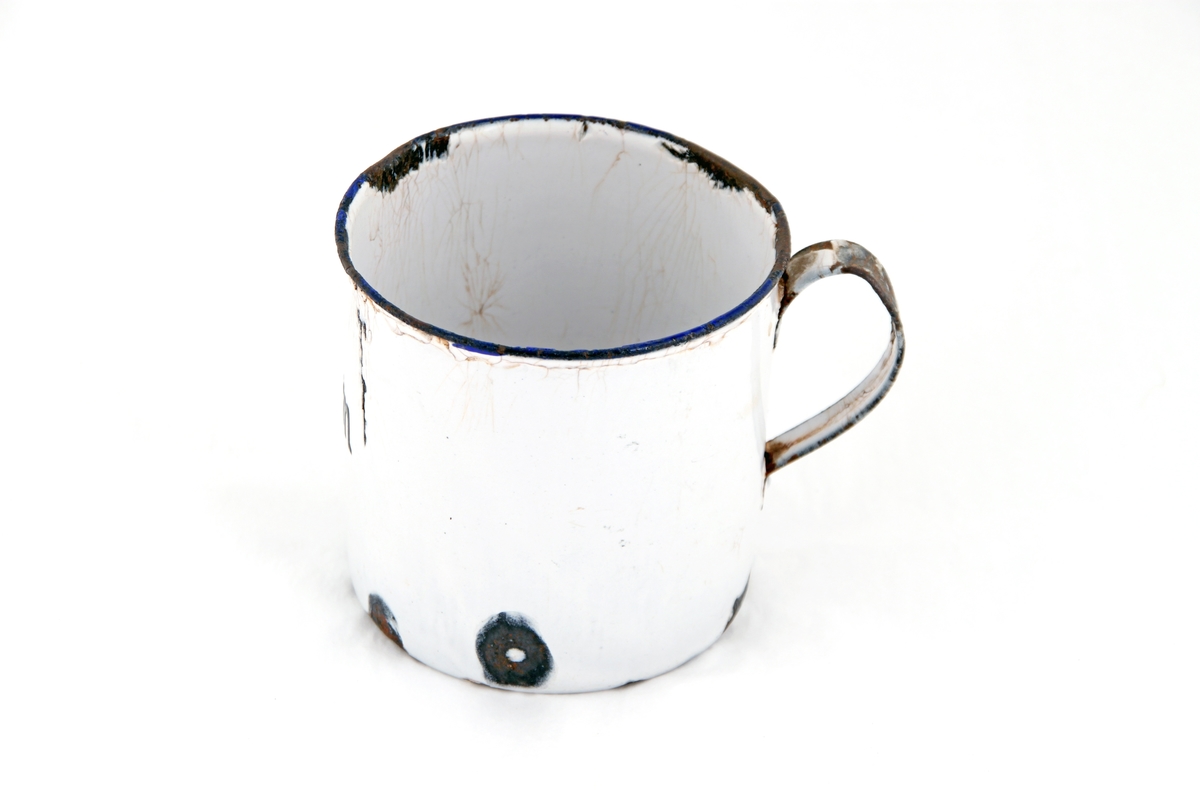 En hvit emaljert kopp med blå rand rundt drikkekanten. På koppen står det "fram" i svart.
