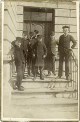 Sju gutar i trapp utanfor bygning i Langes gate på Sydneshau