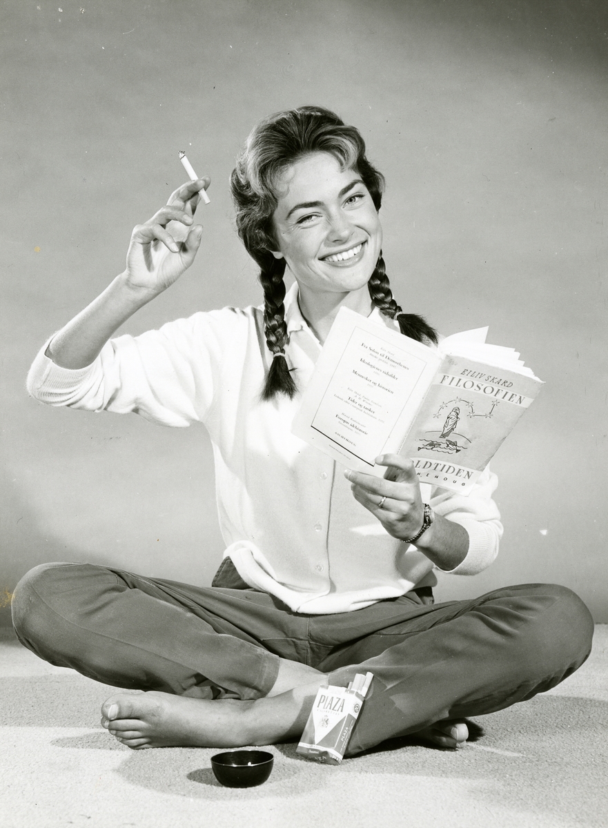 Portrett av kvinne som leser filosofibok og røyker Plaza sigaretter.
