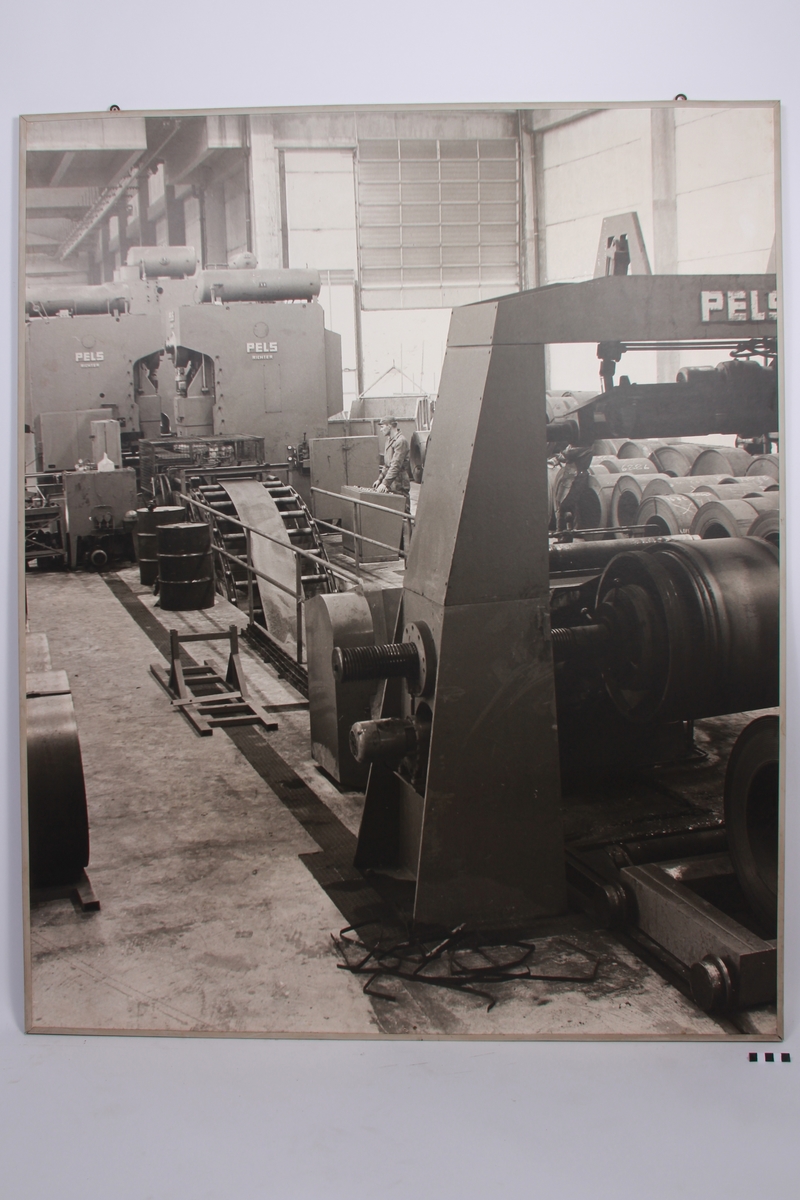 Mann står ved et industrimaskin for å kutte opp stål ved Kvernelands Fabrikk AS på Øksnevad.