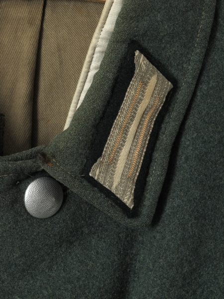 Enkeltspent uniformsjakke, m. 4 lommer utv. Slitt og delvis ødelagt.
