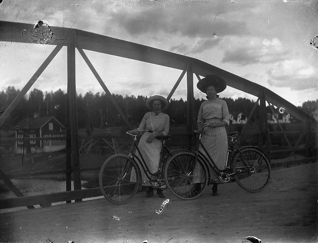 Två kvinnor med cyklar.