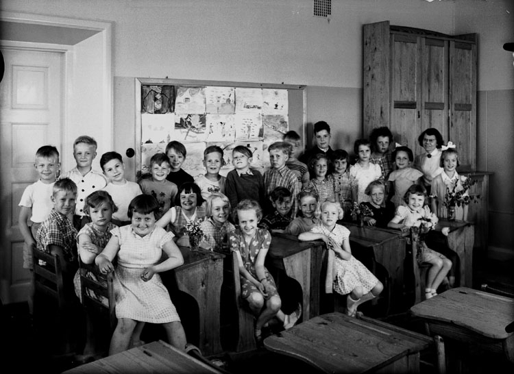 Almby Östra skola, klassrumsinteriör, 27 skolbarn med lärarinna fröken Karin Ohlsson.
Klass 2at, sal 7.