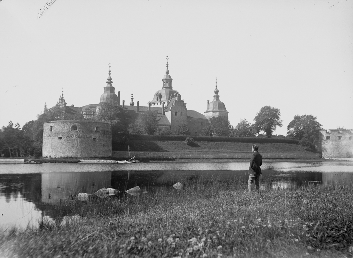 Karl Hedström vid Kalmar slott. Han står nord/nordost om slottet vid kanten av Sylvanderparken. Vattenspegeln åt höger i bild är Slottsfjärden.