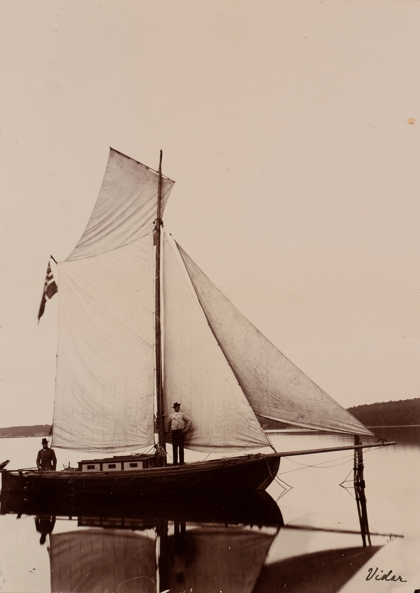 Seilbåten "Vidar" på vannet med to menn ombord. Mannen til venstre er trolig Kai Möller.
