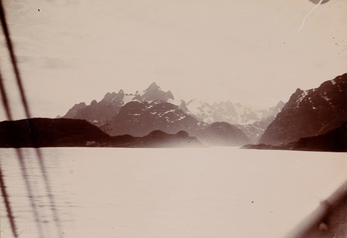 Fjord og snødekte fjell sett fra båten.