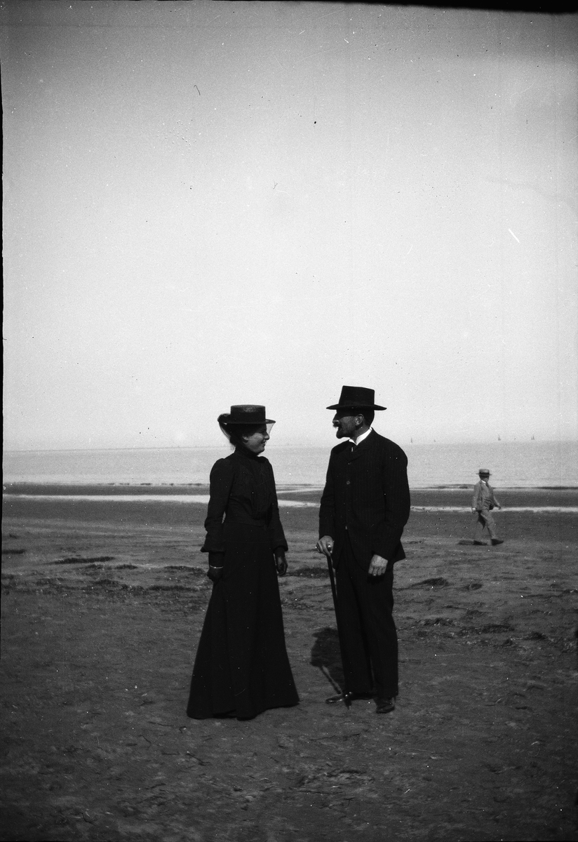 Drottning Victorias bilder. En man och en kvinna på stranden.