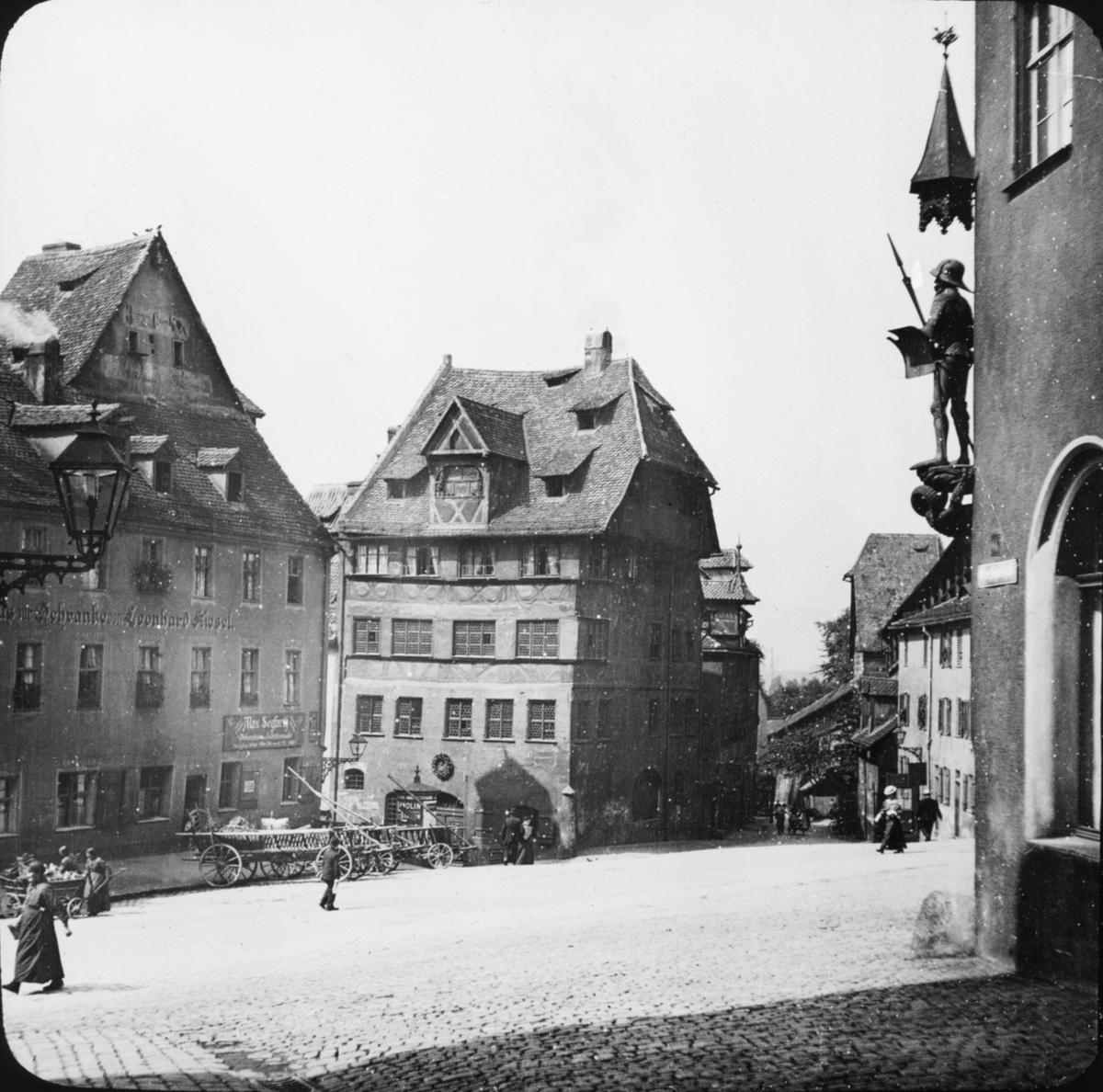 Skioptikonbild med motiv av Dürerhaus (teater?), vid torg i Nürnberg.
Bilden har förvarats i kartong märkt: Resan 1907. Nürnberg 11. 26. Text på bild: "Dürerhaus".