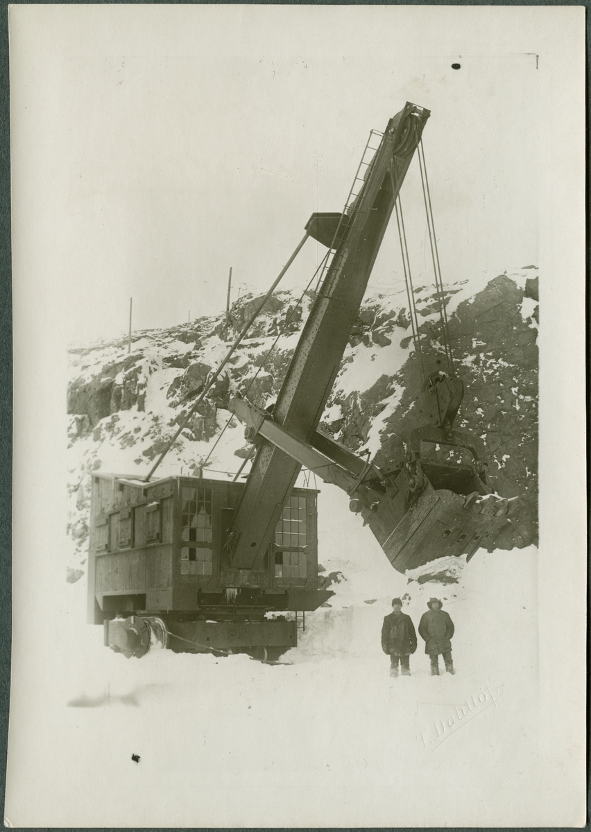 Två män vid grävskopa med lyftkran vid gruvan i Kiruna. På bildens baksida står det Gustaf Horn.