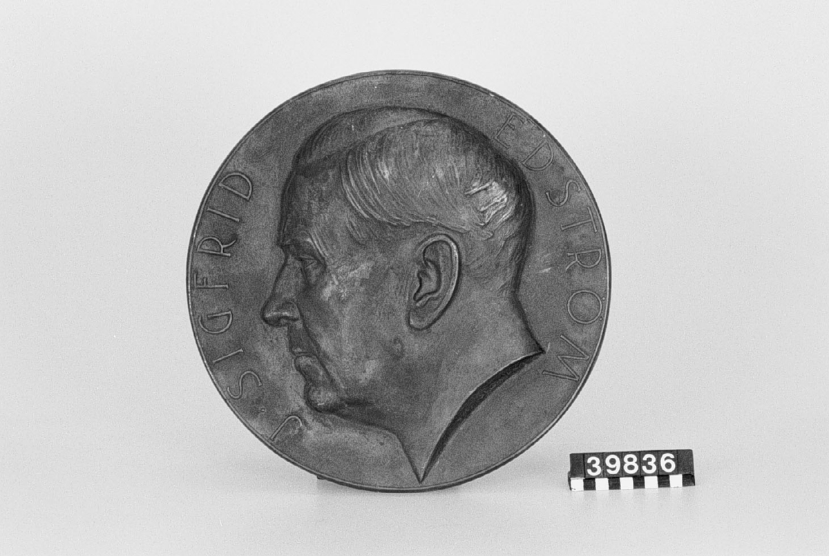 Medaljong av brons, J.Sigfrid Edström. Konstnärens namn T. Strandberg?