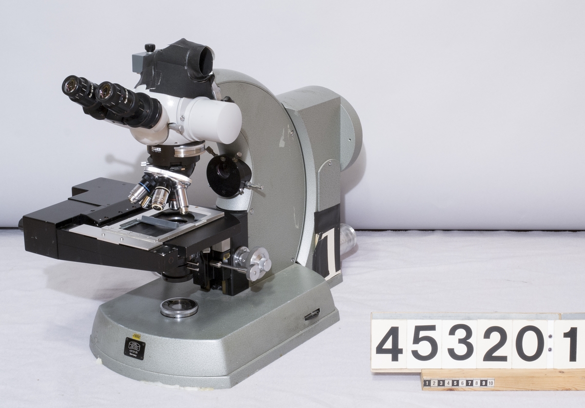 Zeiss ljusmikroskop med motoriserat objektbord.Tillhörande filterenhet för ljus, ej monterad på mikroskopet. Med platta av järn att använda som underlag.