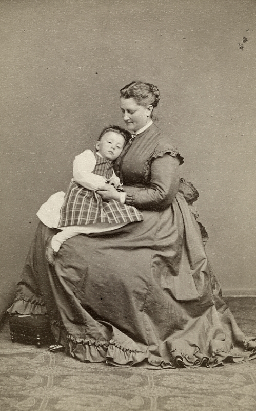 En kvinna och en liten flicka.
Prostinnan Sofia Nikolina "Siffi" Ekström (1832-1903), född Lagerholm (Wilhelminas syster) med fosterdotter.
Gift med Albert Ekström, hovpredikant i Vingåker.