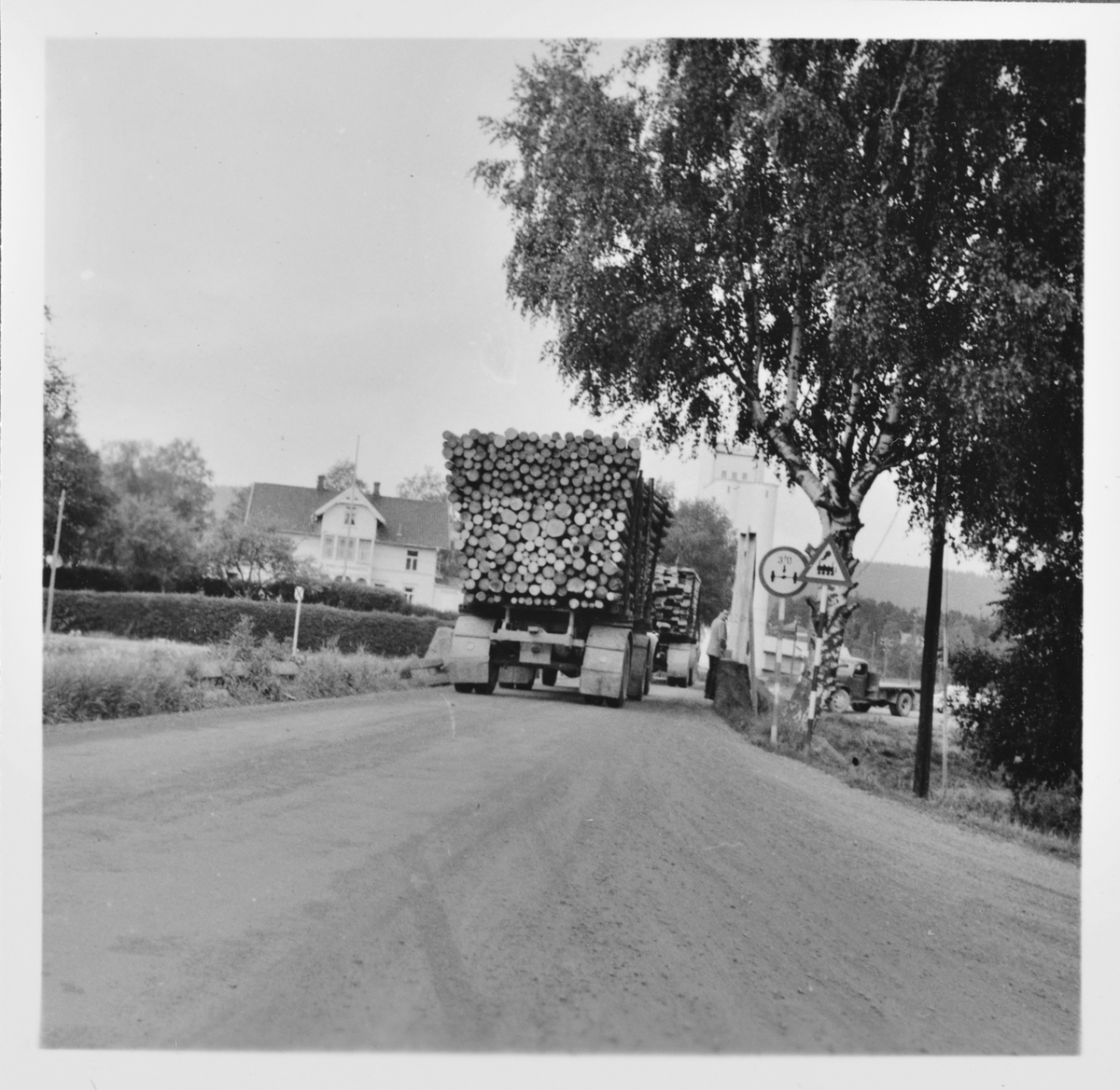 Tømmerbil passerer Kjelle bro på Bjørkelangen. Tømmertransporten ble overtatt av lastebiler etter Urskog-Hølandsbanens nedleggelse 30.6.1960.