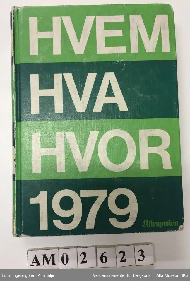 Liten bok med grønne striper. Tittelen på boka har store blokkbokstaver: "Hvem - Hva - Hvor 1979".