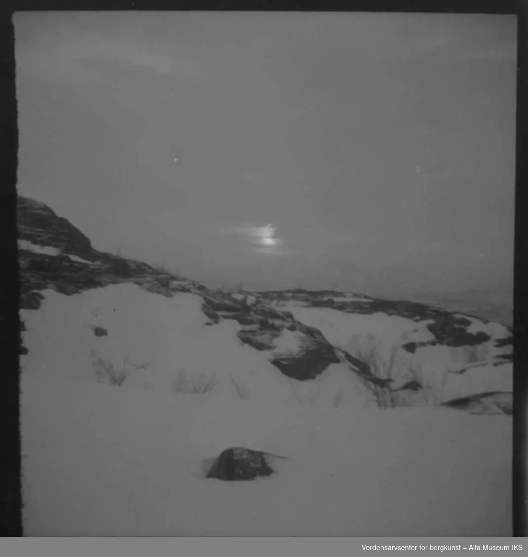 Bilde av komsatoppen med snø og sol.