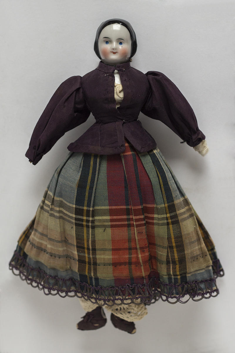 Denne dukken fra rundt 1860-1870 er kledd i en vakker og omstendelig drakt.