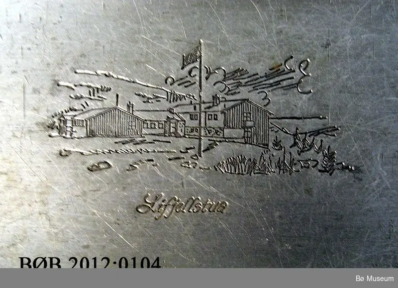 Bilde av Lifjellstua er trykt inn i fatet, midt på. Bord rundt kanten av fatet.