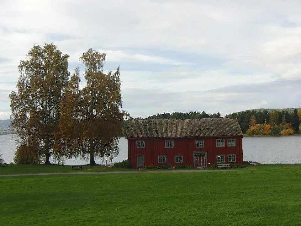 Løtenbygningen er et stort, rødmalt trehus i to etasjer som ligger idyllisk til helt nede ved Mjøsa.