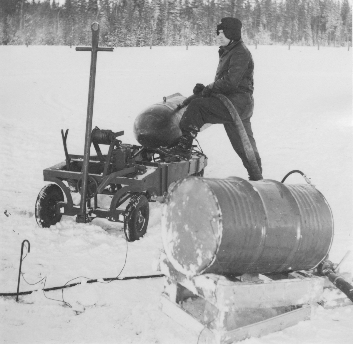 Påfyllning av bränsle till flygbomb från fat till kapsel, 1940-tal. En man i arbete.