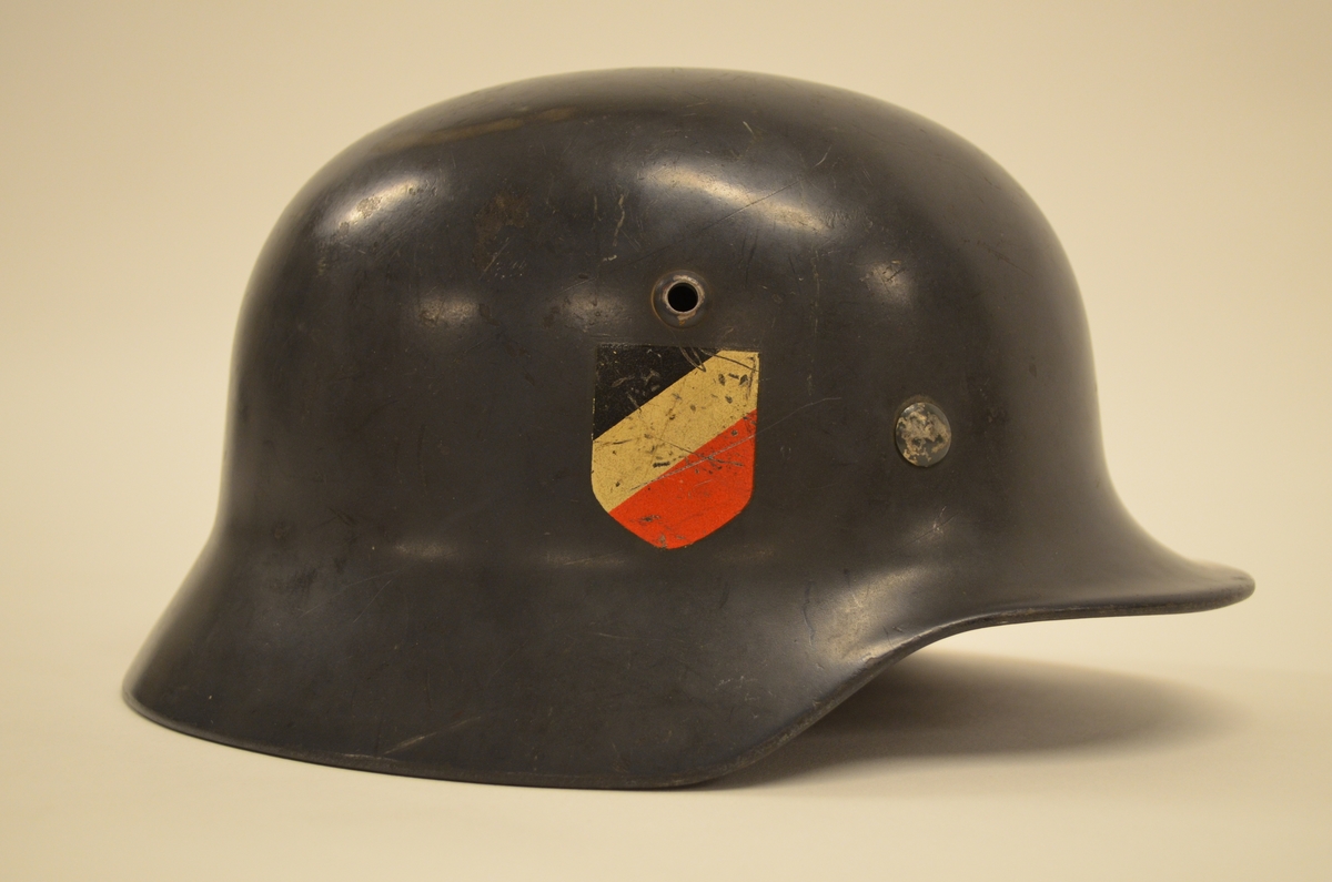 Tyskerhjelmen, "Stahlhelm M 35", ble opprinnelig brukt av en soldat som tjensestegjorde under den tyske okkupasjonsmakten  i Norge i 1944-45. På utsiden er hjelmen grå-blå, hjelmdecal med den tyske ørn og hakekors i gull med svarte kanter på venstre side, Kokarde i de tyske nasjonalfargene, svart, hvitt og rødt på høyre side.  På innsiden er hjelmen "foret" med lær.