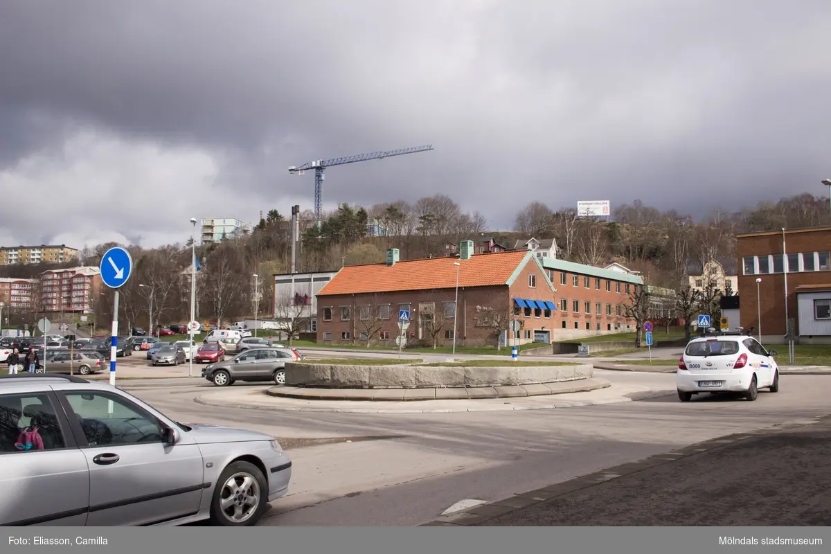 Mölndals brandstation sedd från rondellen på Järnvägsgatan mot Torggatan. Till höger ligger Kvarnbyskolan. På höjden ser man en lyftkran vid nybygget av lägenheterna på Kvarnbyvallen. Det röda tegelfärgade bostadsområdet till höger ligger på Torggatan 64.