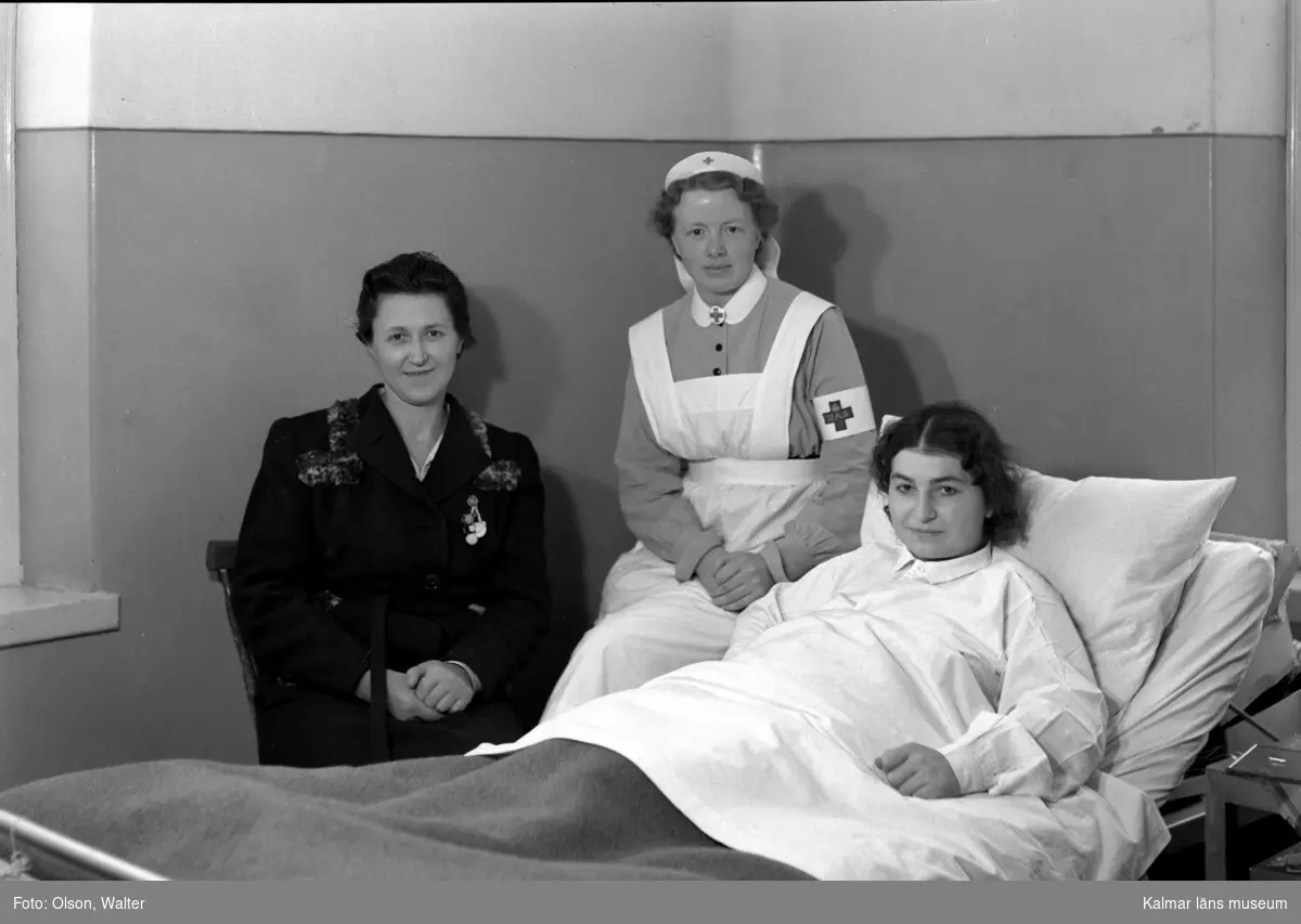 Kvinnlig sängliggande patient med besökare och sköterska på Beredskapssjukhuset.