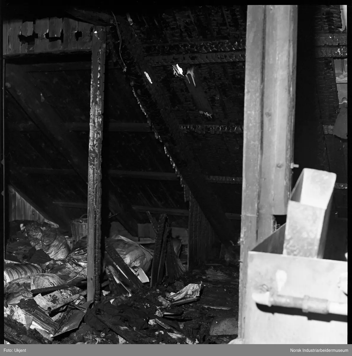 Ødeleggelser etter brann på loft i firemannsbolig.