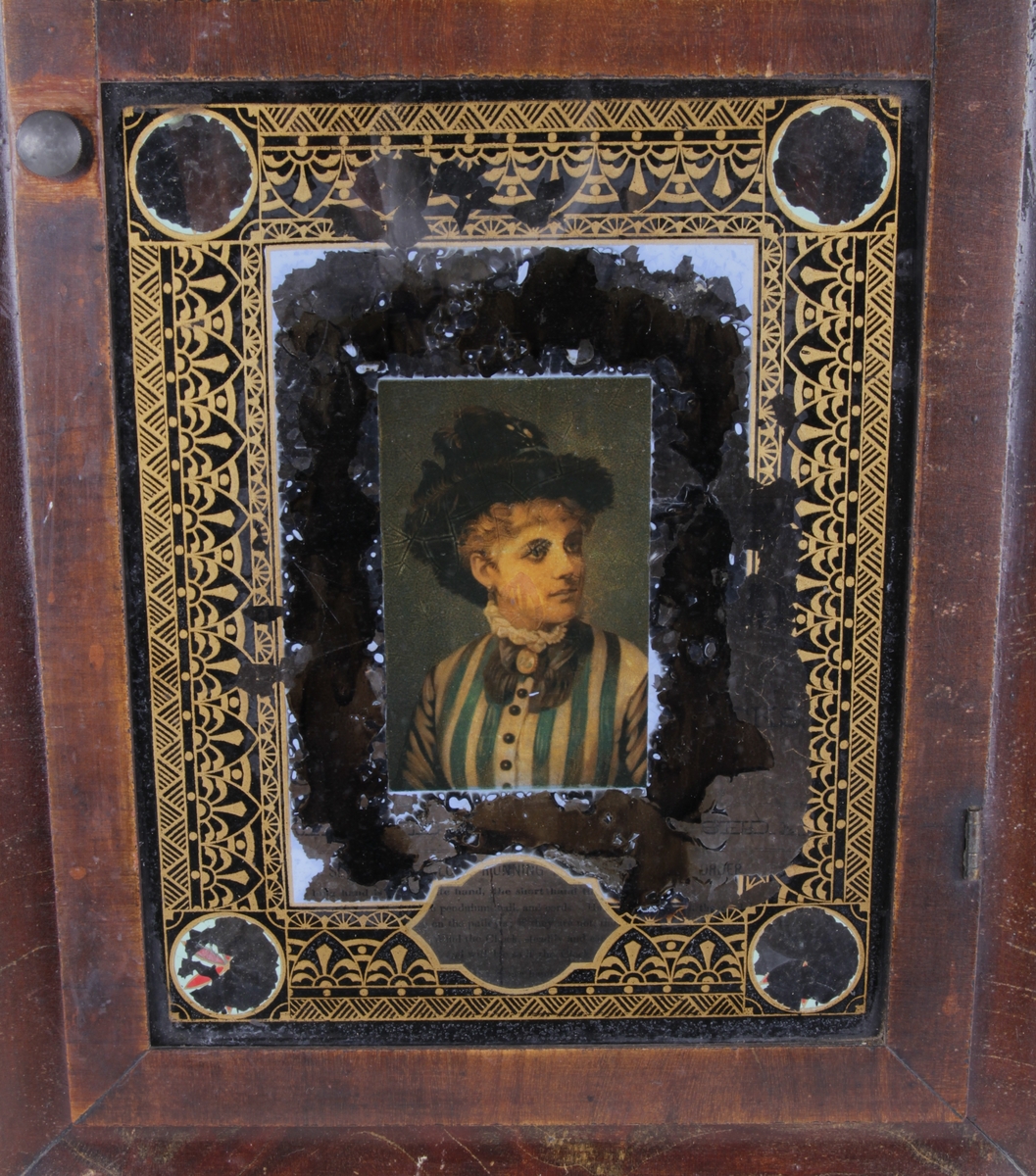 Vitrinen er dekorert med et kvinneportrett omkranset av en gullbord.