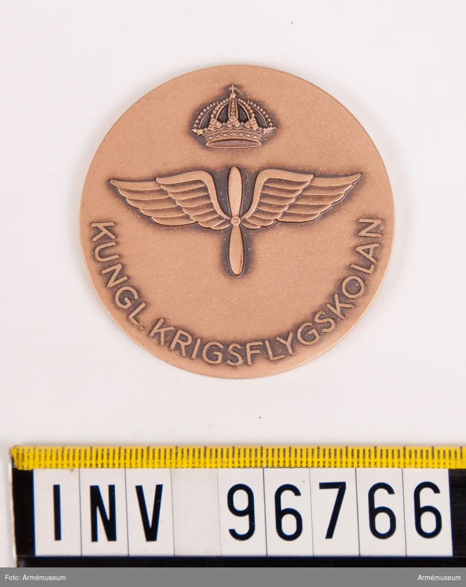 Medalj i brons för Krigsflygskolan.
Medalj, åtsida med bevingad propeller och kunglig krona jämte inskription KUNGL. KRIGSFLYGSKOLAN.
Stans nr 47994 (13602).
Stans härdad 1946-01-10.
Stans 2745, härdad 1941-11-11.