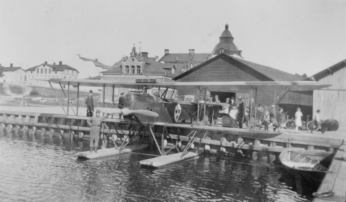 Sjöflygplan S 1 vid hamnen i Örnsköldsvik. Människor i rörelse på kajen.