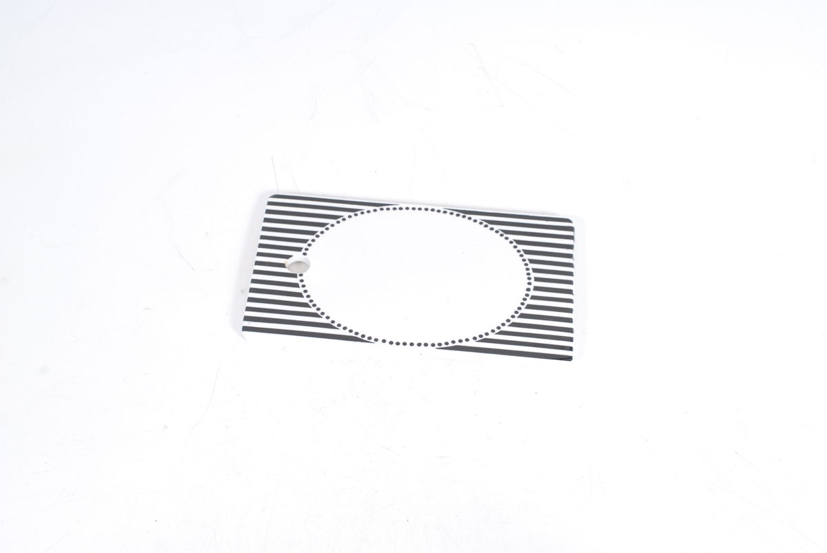 oval innrammet av svarte prikke, svarte og hvite striper 