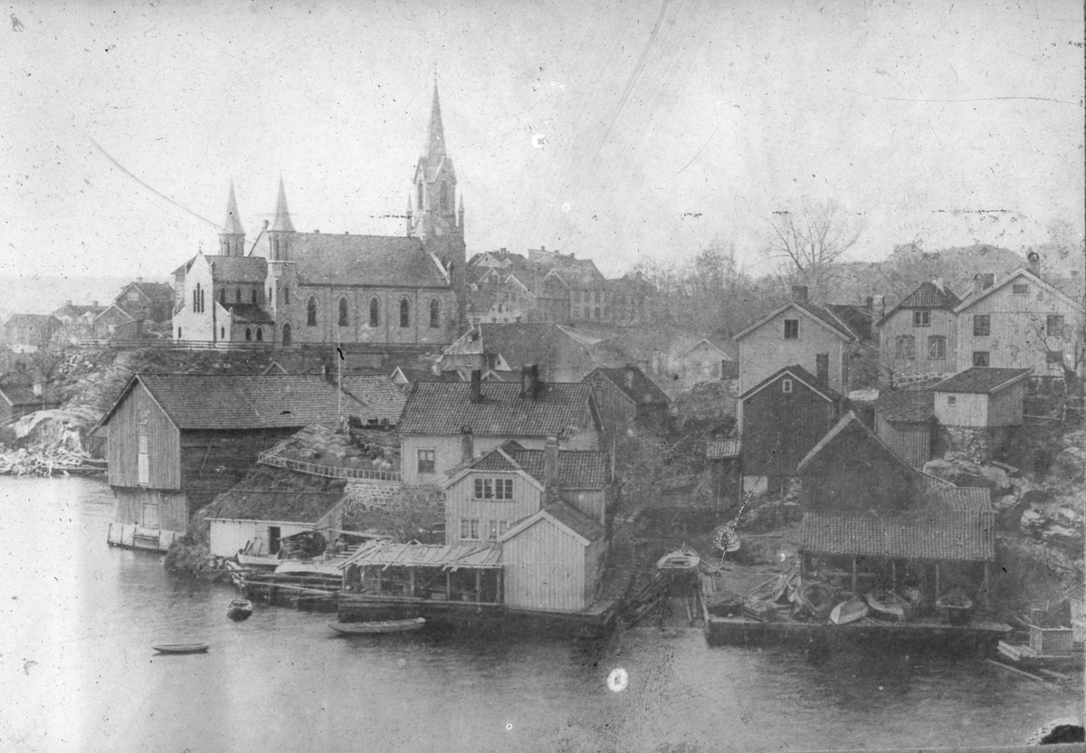 Bebyggelse ved Jørandsberg, Kirkebukta, Kragerø. Kragerø kirke i bakgrunnen.Bildet er trolig tatt før bybrannen i 1886.