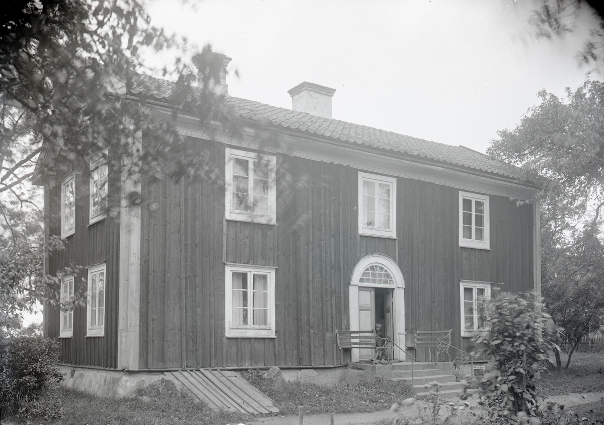 Mangårdsbyggnad med utsirad huvudingång i Åby s:n.