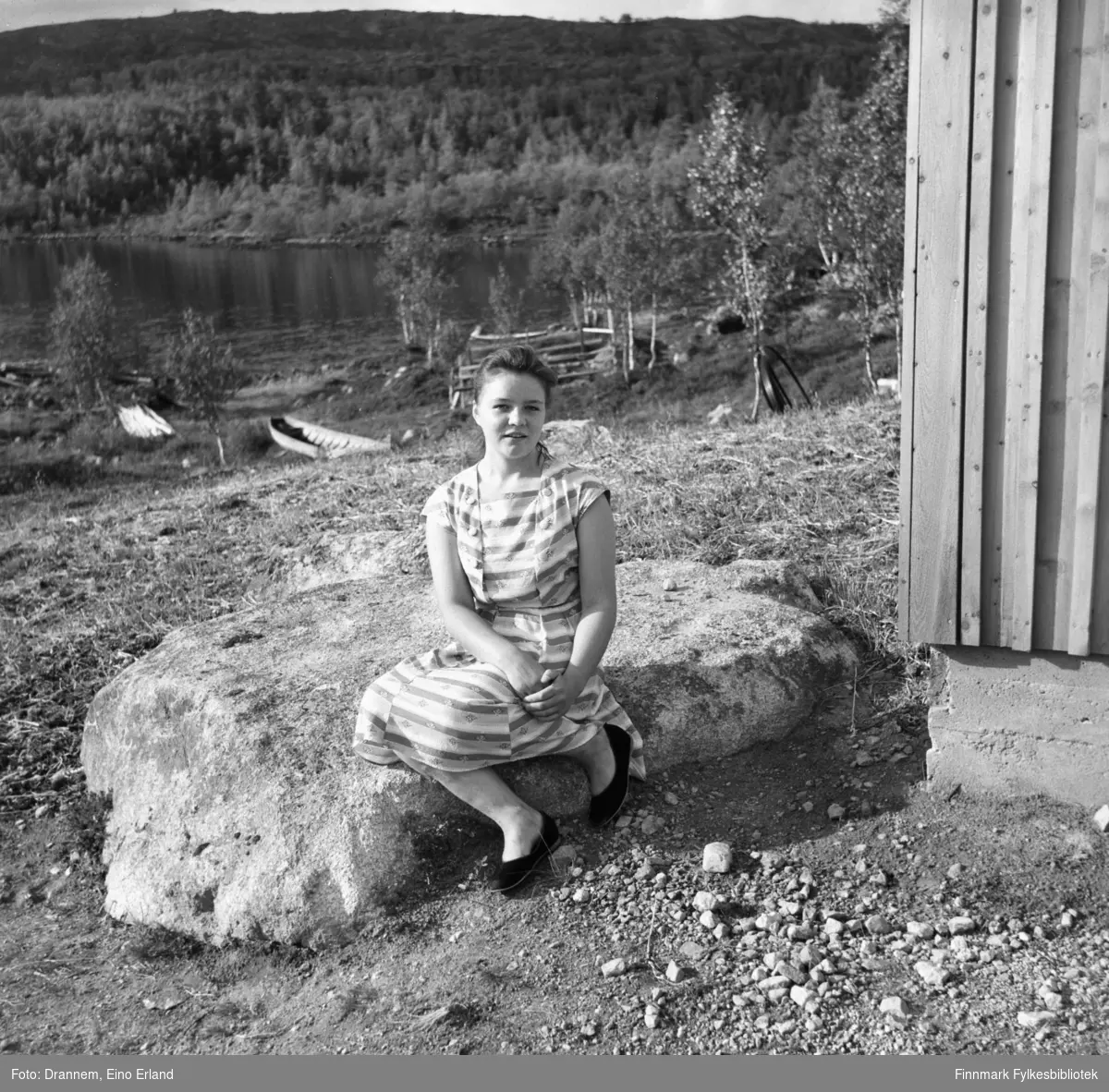Maija Hoikka (født Gerasimoff) sitter på en stor, flat stein iført sommerkjole. Stedet er Luolajärvi.