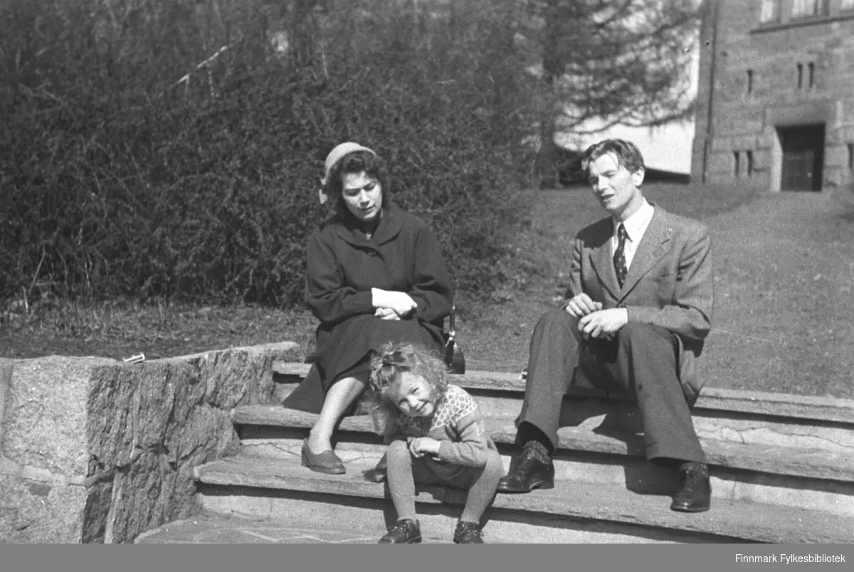 Familien Drannem sitter på en trapp. Jenny til venstre og Eino til høyre på bildet. Turid sitter i midten. Bildet er tatt i Oslo.