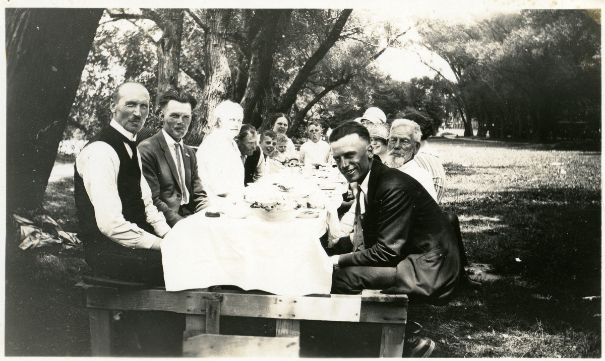 Barn og voksne rundt et dekket bord i en bypark i Madison, Wise. Olaus Islandsmoen til venstre. Peder Hansen Islandsmoen og Gurine er også på bildet.