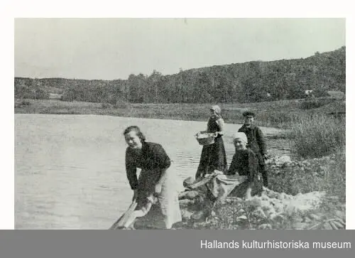 "Stortvätt. Anna, Hildur, Elin och Ivar Emanuelsson har stortvätt vid sjön Dran, Veddige 1920.Bilden ingick i Museets i Varberg bildtävling/utställning, ""Byakistan"", 1975.  Se VMA11638: serie F5."