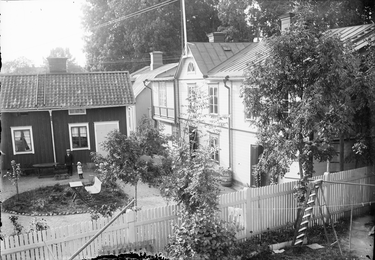 Handlande Robert Almgrens med familj på sin gård i hörnet av Drottninggatan och Kyrkogatan, Östhammar