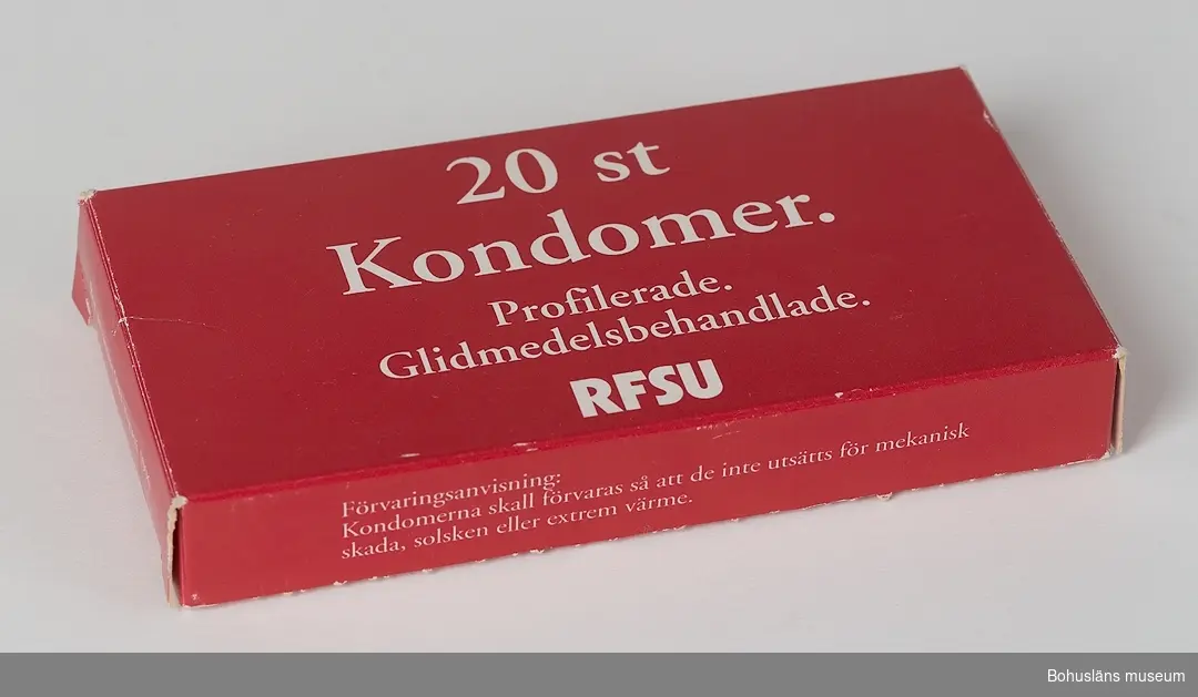 Kondomförpackning från RFSU av röd papp med påtryck i vitt. 
20 st.
Kondomer. 
Profilerade. 
Glidmedelsbehandlade.
RFSU
Instruktionstext med teckningar och produktfakta på förpackningens baksida. Öppnad, troligen från 1980-talets slut. Bäst före-datum augusti 1996.

12 st kondomer i förpackningen.