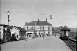 Hønefoss stasjon med reisende og persontog mot Randsfjordban