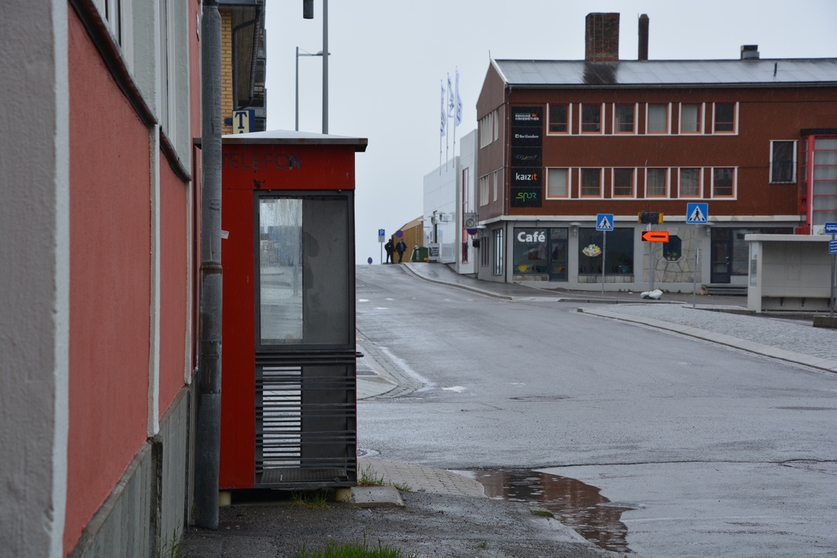 Denne telefonkiosken står ved Hurtigrutekaia i Hammerfest, og er en av de 100 vernede telefonkioskene i Norge. De røde telefonkioskene ble laget av hovedverkstedet til Telenor (Telegrafverket, Televerket). Målene er så å si uforandret. 
Vi har dessverre ikke hatt kapasitet til å gjøre grundige mål av hver enkelt kiosk som er vernet. 
Blant annet er vekten og høyden på døra endret fra tegningene til hovedverkstedet fra 1933.
Målene fra 1933 var:
Høyde 2500 mm + sokkel på ca 70 mm
Grunnflate 1000x1000 mm.
Vekt 850 kg.
Mange av oss har minner knyttet til den lille røde bygningen. Historien om telefonkiosken er på mange måter historien om oss.  Derfor ble 100 av de røde telefonkioskene rundt om i landet vernet i 1997. Dette er en av dem.