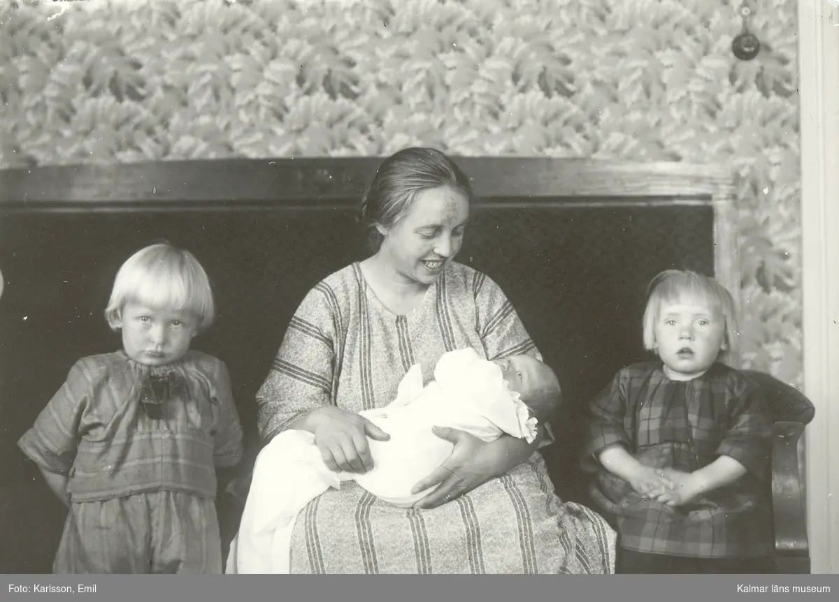 Fru Greta Johansson Myrsäter flankerad av barnen Ivan, född 1920 och Ingrid född 1921 gift Persson, och liggande i knät sonen Sven född 1923.