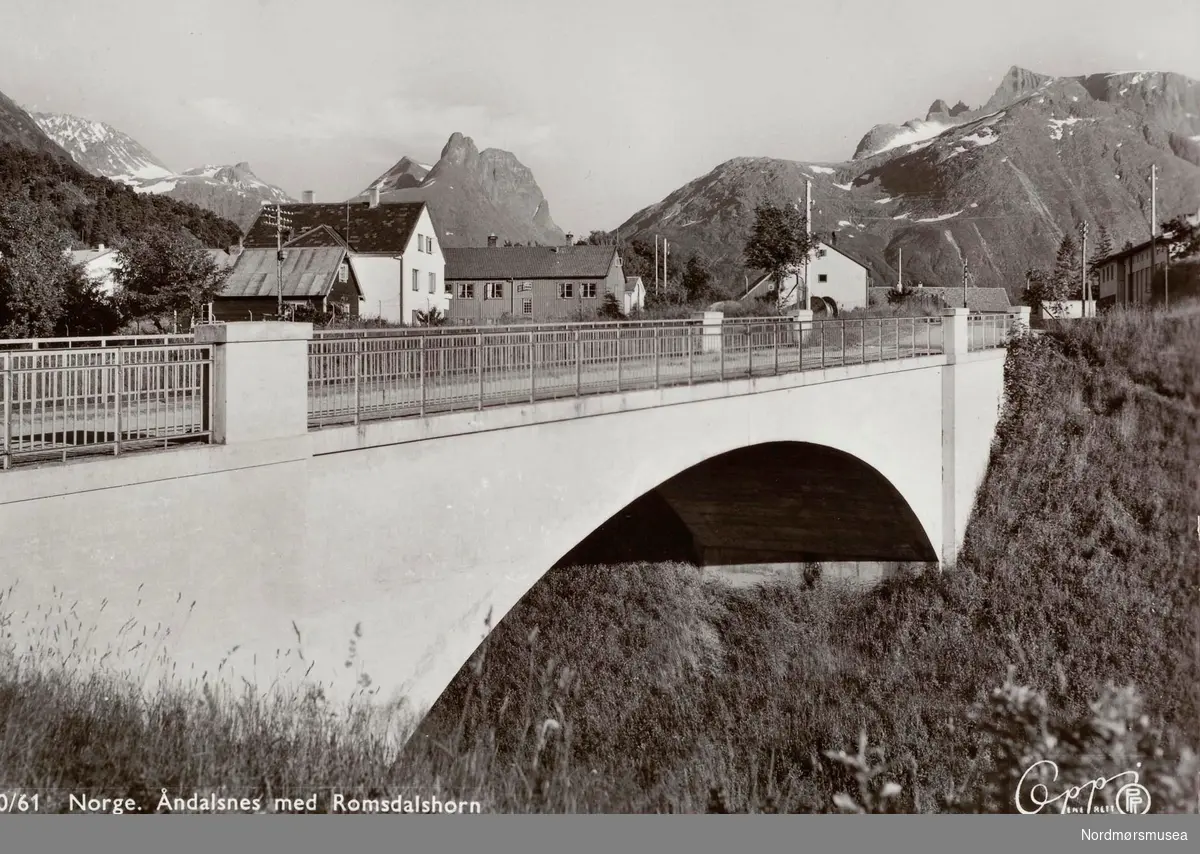 Postkort ";10/61"; med motiv fra Åndalsnes, sett mot Romsdalshorn. Utgitt av Eberh. B. Oppi A/S. Fra Nordmøre Museums fotosamlinger. Reg: EFR

