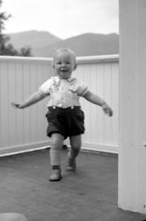 Foto av en liten gutt på en veranda. serie. Gutten er Per Ge