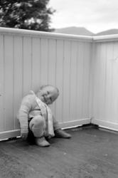 Foto av en liten gutt på en veranda. Gutten er Per Georg Sve